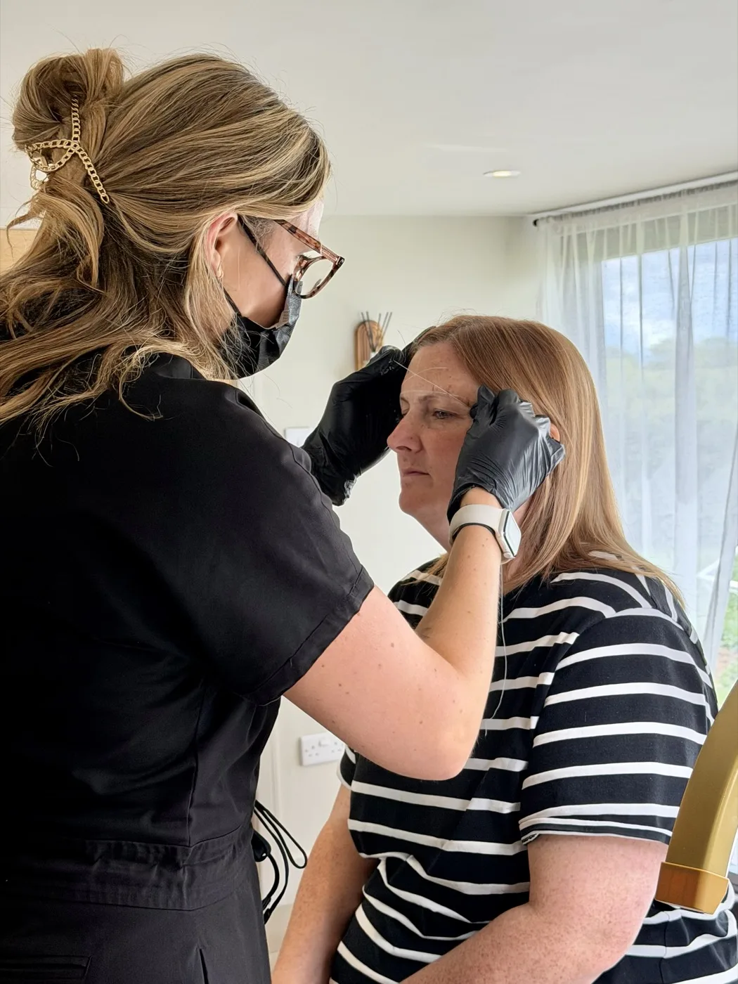 Sophie mapping a client's eyebrows