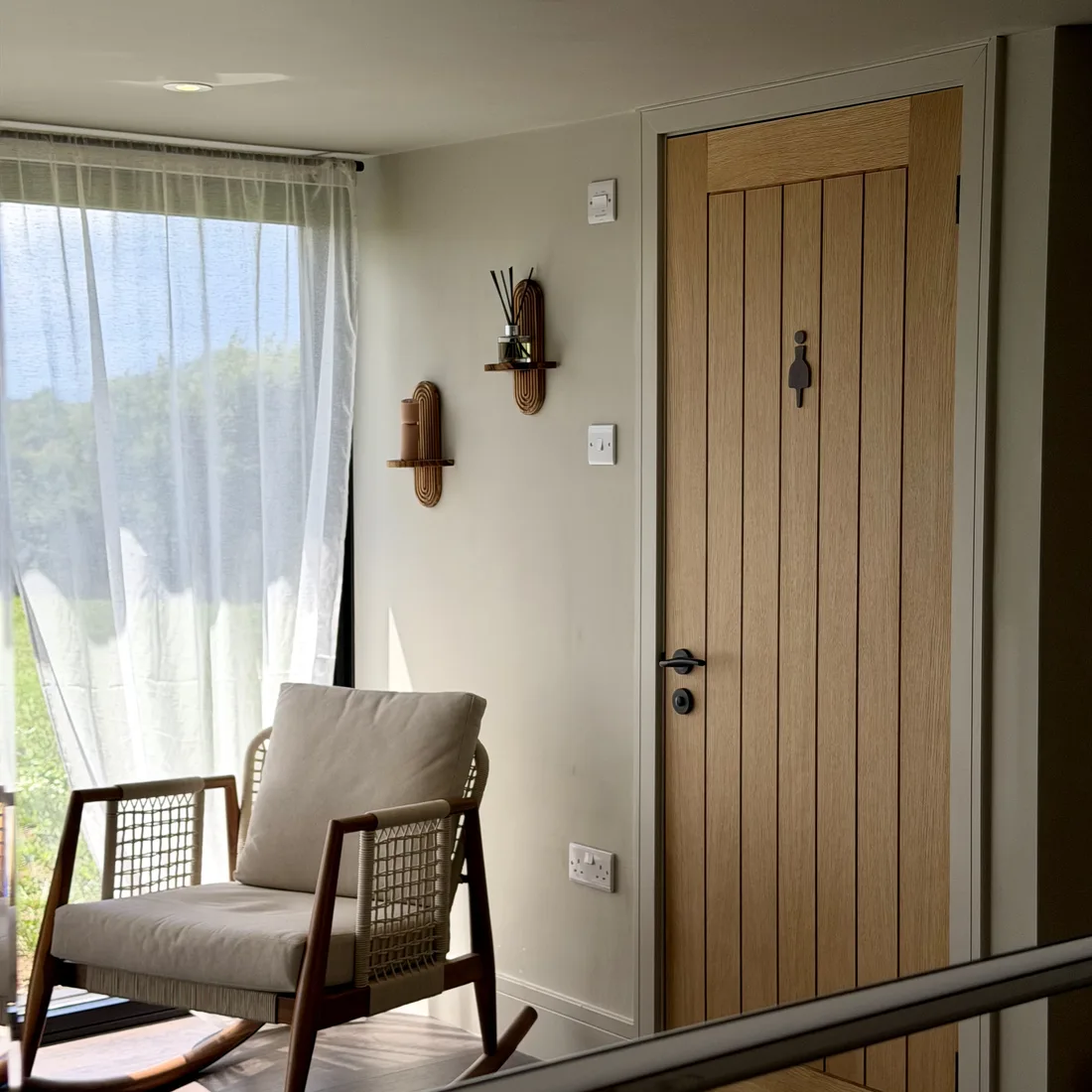 A quiet corner of the studio, a rocking chair by the window with the field beyond